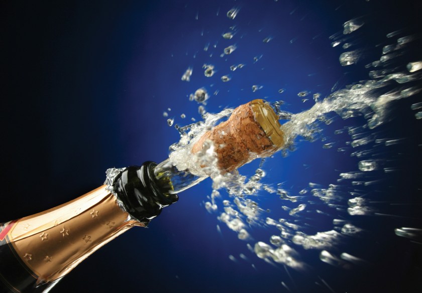 A bottle of champagne being uncorked.